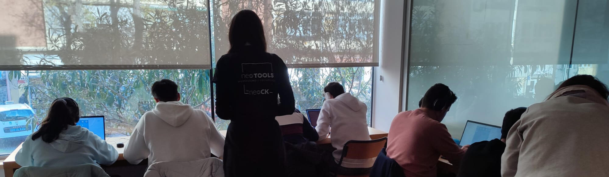 Fotografía tomada en una de las experiencias neoTOOLS, varios adolescentes sentados frente a sus computadoras